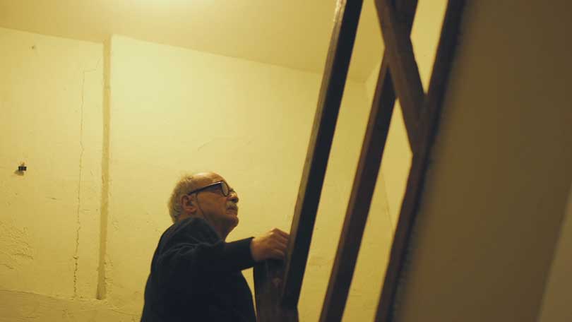 Conflict photographer looks up a staircase in an industrial building